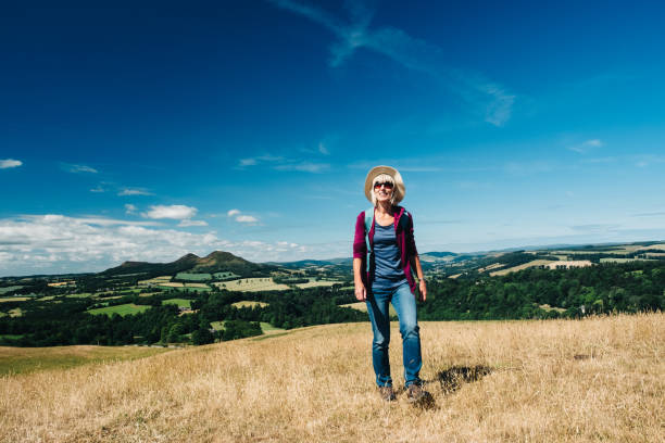 istock Active senior woman walking on a grass meadow 998656302