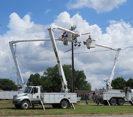 linemen in utility truck working on electrical equipment