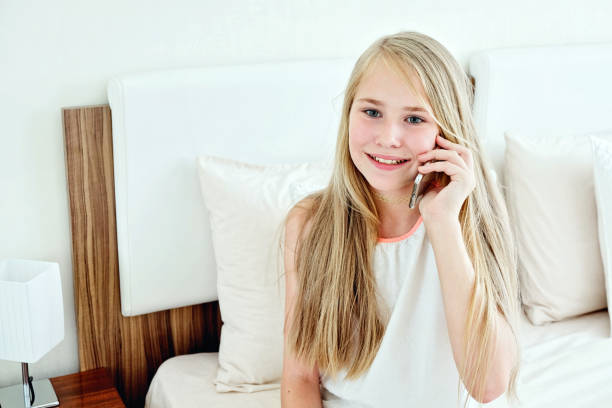 istock Teenage Girl Lying On Bed Using A Mobile Phone 998660436