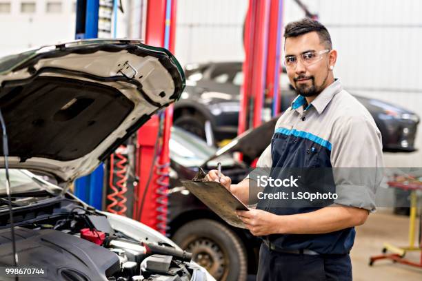 Handsome Mechanic Job In Uniform Working On Car Stock Photo - Download Image Now - Mechanic, Car, Machinery