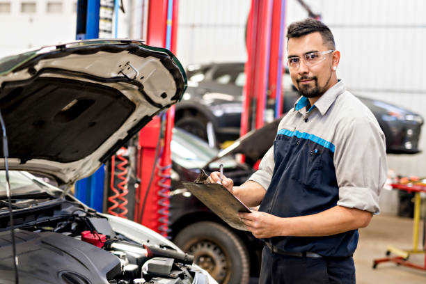 handsome mechanic job in uniform working on car - car equipment smiling working imagens e fotografias de stock