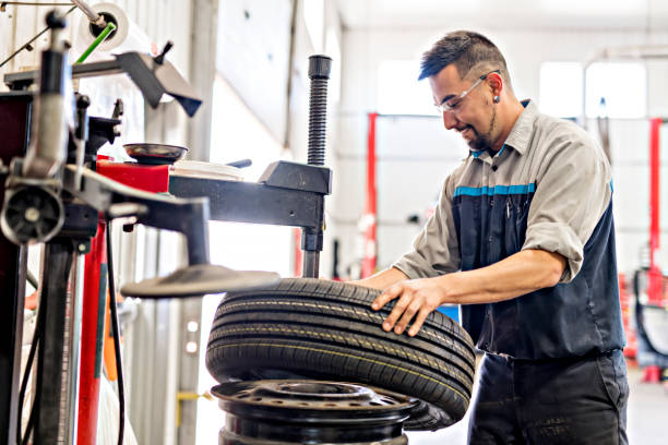 mécanicien, changement de pneu de voiture au travail - mechanic technician working human hand photos et images de collection