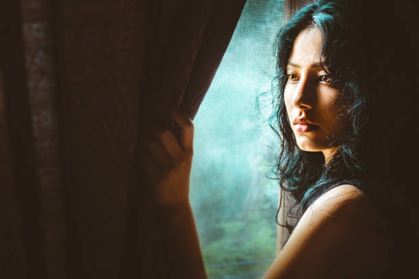 istock Beautiful serene young woman thinks near window. 998671596
