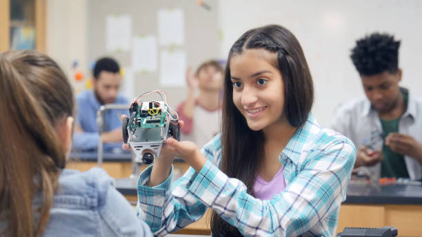 istock Preteen girl gets classmate's advice on robotics project 998687838