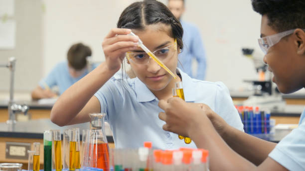 menina pré-adolescente realiza experiência química com o parceiro de laboratório - science child laboratory education - fotografias e filmes do acervo