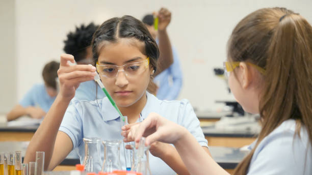 istock Preteen girl uses precision during school science experiment 998687912