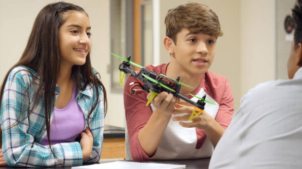 istock Teenage boy discusses hovercraft project with classmates 998687914