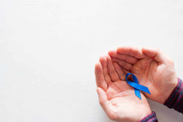 istock man holds a blue ribbon on a white background with space for text 998688584