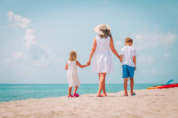 istock mother with kdis-son and daughter- walking on beach 998702490