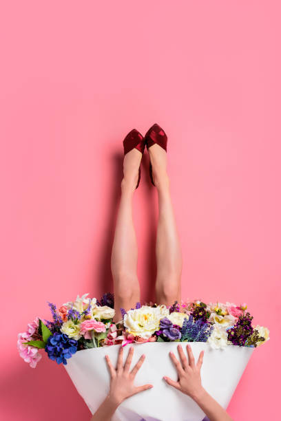 upside down of girl in high heeled shoes and skirt with beautiful flowers isolated on pink - garment fragility women skirt imagens e fotografias de stock