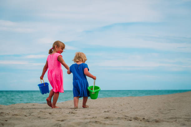 istock little girls walking on beach 998703642