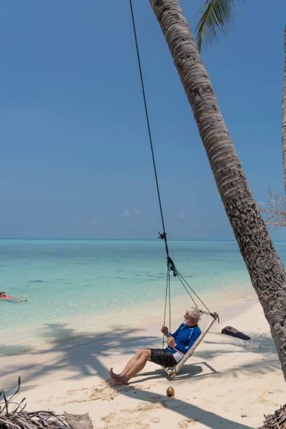 istock Senior man in hammock on the beach 998707142