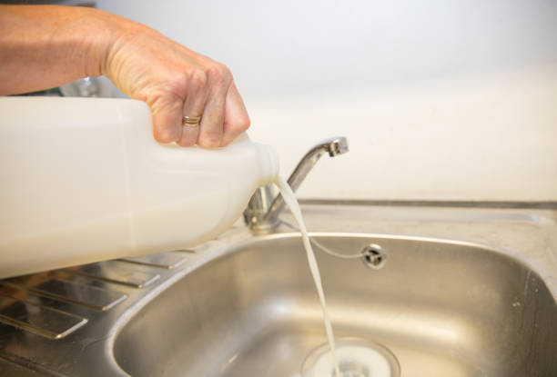 istock Fresh milk being poured down a stainless steel sink, waste 998747494