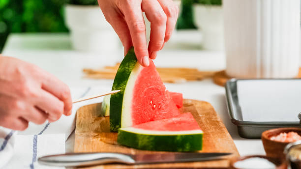istock Sliding the wood pop stick into the watermelon wage wedge 998751100