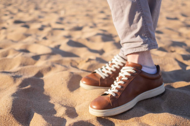 istock Close up image of man walking alone sandy beach with blue ocean and white sand 998754236