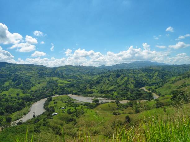 Impressive view of the Cauca river, its valley and the mountains of Colombia Impressive panoramic view of the Cauca River and the valley that forms between the Central and Western Cordilleras of the Andes. Wonderful river that crosses Colombia from south to north. valle del cauca stock pictures, royalty-free photos & images