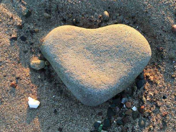 istock Heart rock in the sand at sunset 998816304