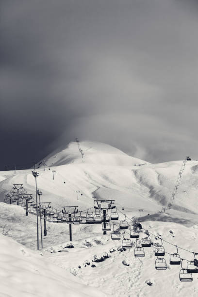 Black and white view on ski slope and ropeways in winter evening. Caucasus Mountains. Georgia, region Gudauri.
