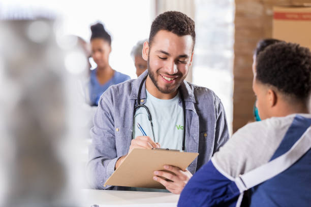 istock Volunteer doctor writing in patient's chart 998833430