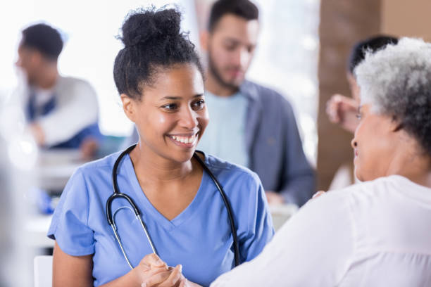 Cheerful nurse talking with senior female patient