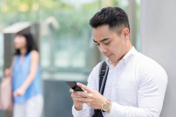 istock Confident businessman looking at smartphone 998835550