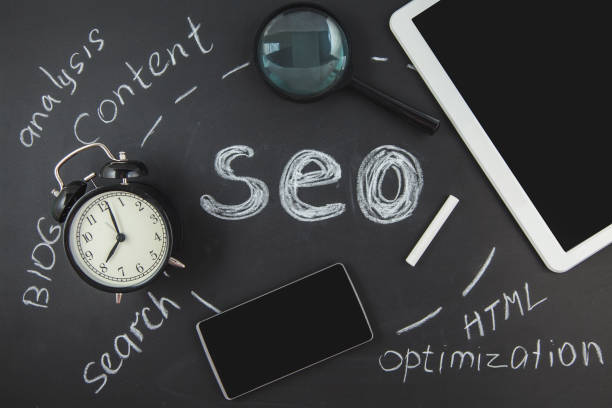 istock SEO Search engine optimization concept Magnifying glass, clock, smartphone on a black background with an inscription SEO Top view 998836504