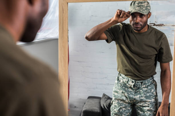 istock Handsome african american soldier putting on cap by the mirror 998843326