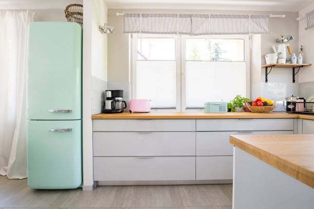 istock Neo mint fridge standing in real photo of bright kitchen interio 998844412