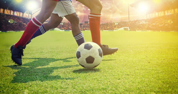 istock Low Section Of Soccer Players Playing On Field 998844598
