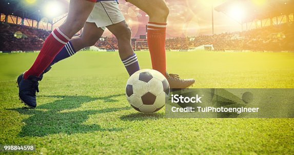 istock Low Section Of Soccer Players Playing On Field 998844598