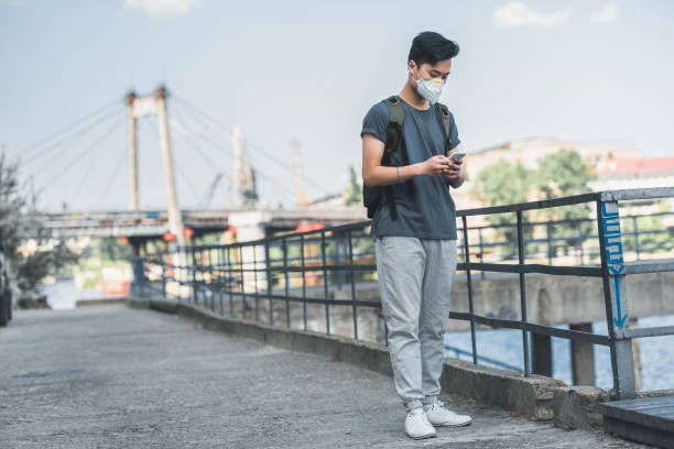 istock asian teen in protective mask using smartphone, air pollution concept 998847232