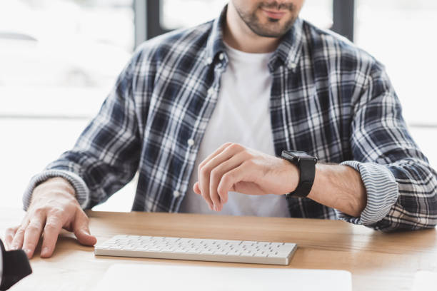 istock cropped shot of young man checking smartwatch while sitting at workplace 998848528