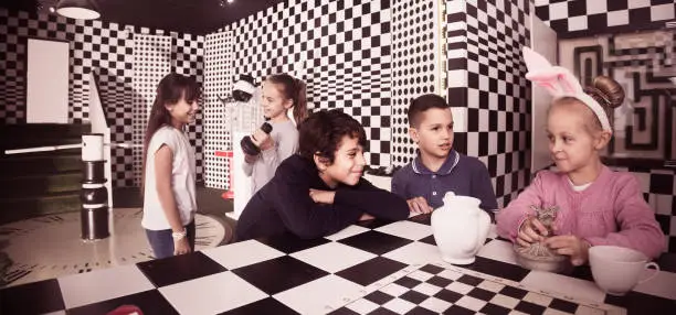 Photo of five  kids discuss the game in the chess quest room