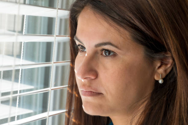 istock Sad mature woman looking through a window 998878296