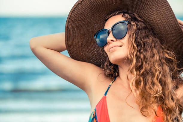 giovane donna felice in spiaggia in vacanza estiva. - thin curls foto e immagini stock