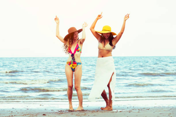 istock Happy women dance on sand beach in summer. 998885134