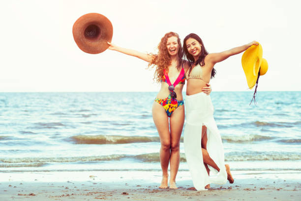 istock Happy women dance on sand beach in summer. 998885140
