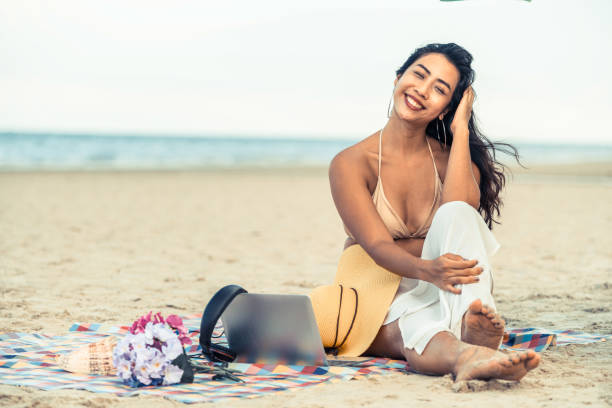 istock Plus size young woman sitting on the beach. 998885178