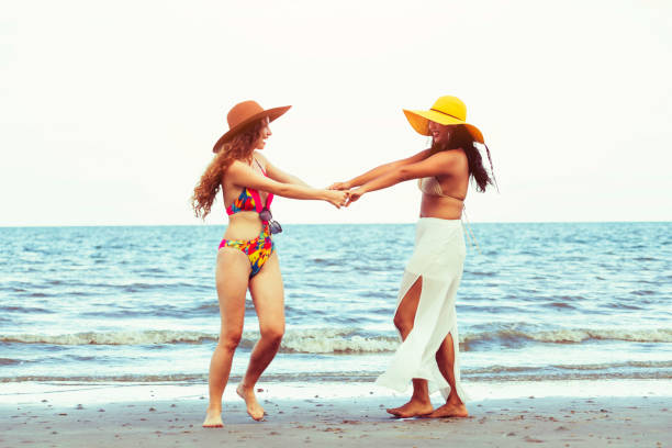 istock Happy women dance on sand beach in summer. 998885294