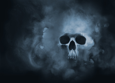 Scary skull emerging from a cloud of smoke / high contrast image