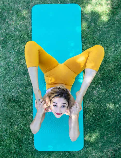 A young woman doing Yoga positions in the park.