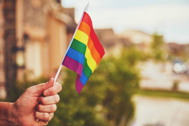 istock Male hand holding rainbow flag 998892700