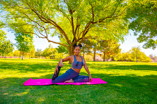 A young woman doing Yoga positions in the park.