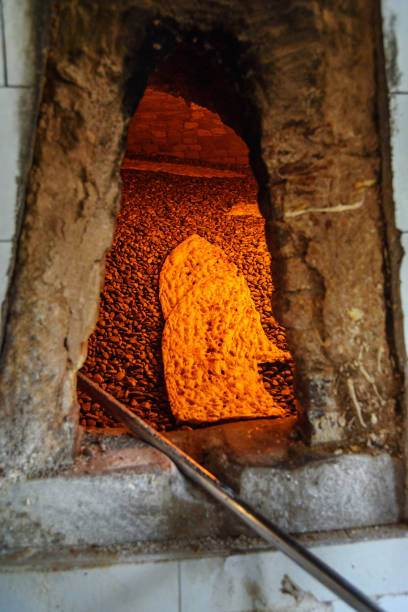 Iranian traditional bread Sangak in the oven on pebbles in small bakery. Khorramabad. Iran