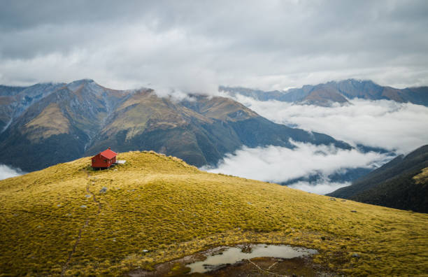 a lonely mountain hut above the clouds in new zealand - passion mountain range mountain national park imagens e fotografias de stock