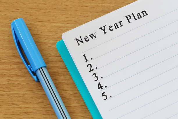 istock Notebook and pen placed on wood desk and New year plan text. 998922946