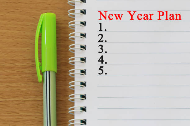 istock Notebook and pen placed on wood desk and New year plan text. 998923184