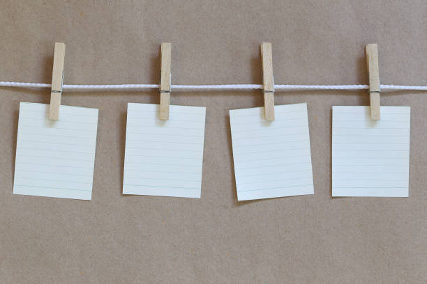 istock Notepad empty hanging on a rope and brown paper background. 998923348