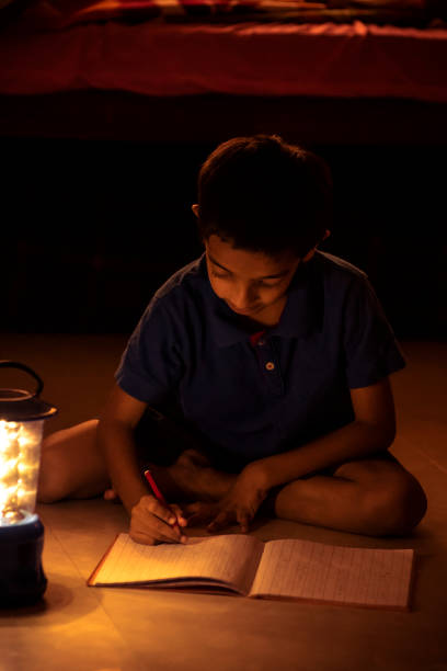 istock 7 years Indian Boy studying under lamp 998926088