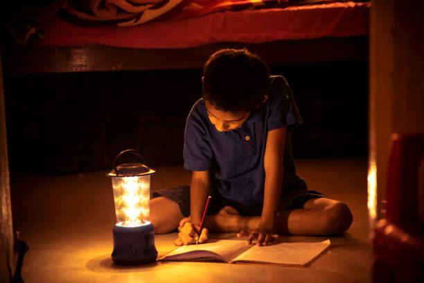 7 years Indian Boy studying under lamp